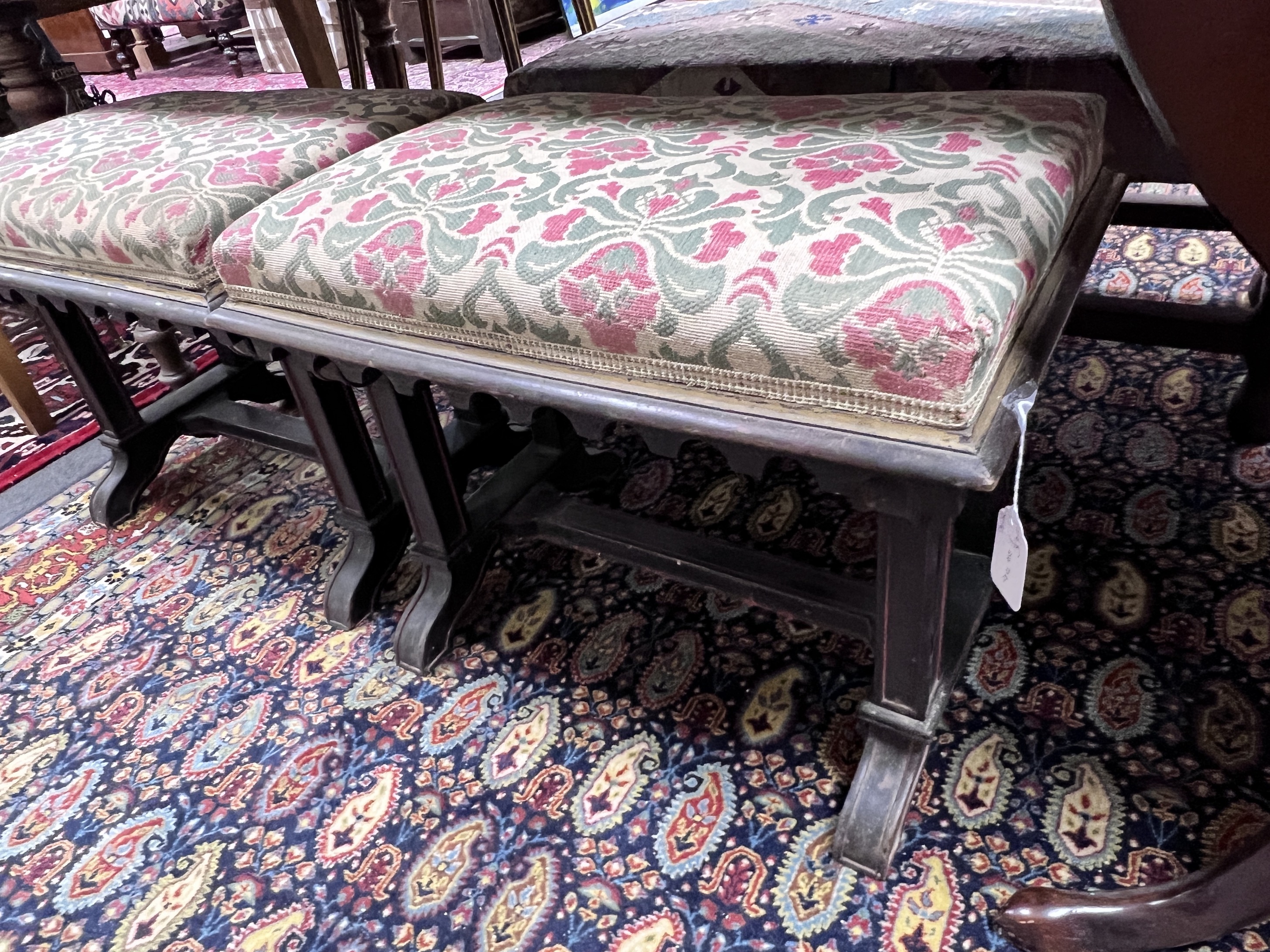 A pair of Victorian upholstered and ebonised stools of neo Gothic design, width 58cm, height 47cm